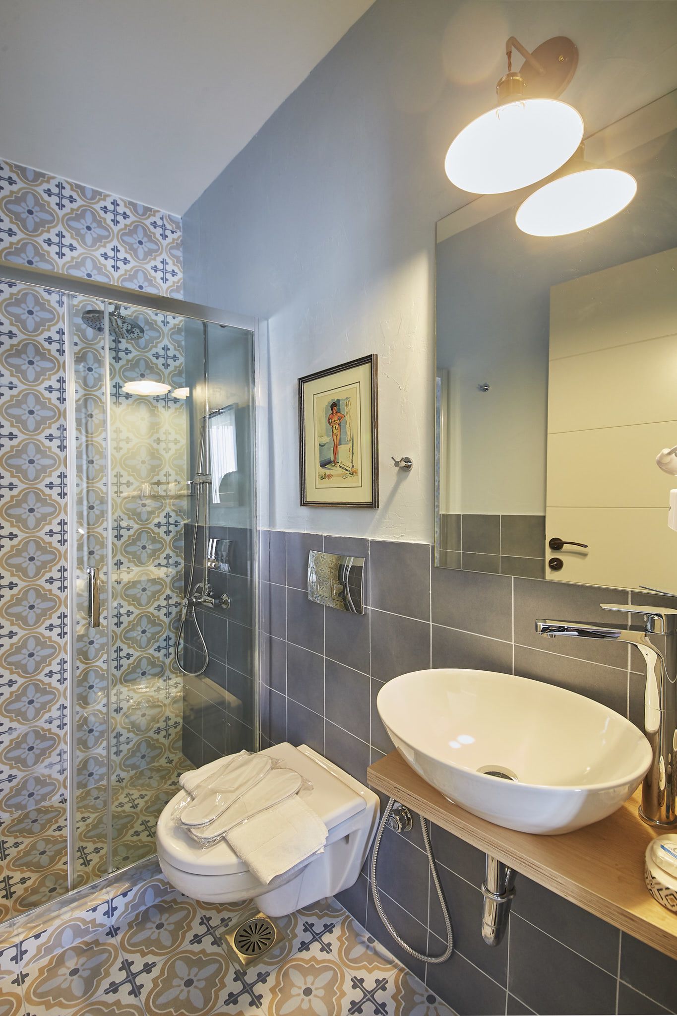 A bathroom with a glass-enclosed shower, a white sink, and a mirror above the sink.
