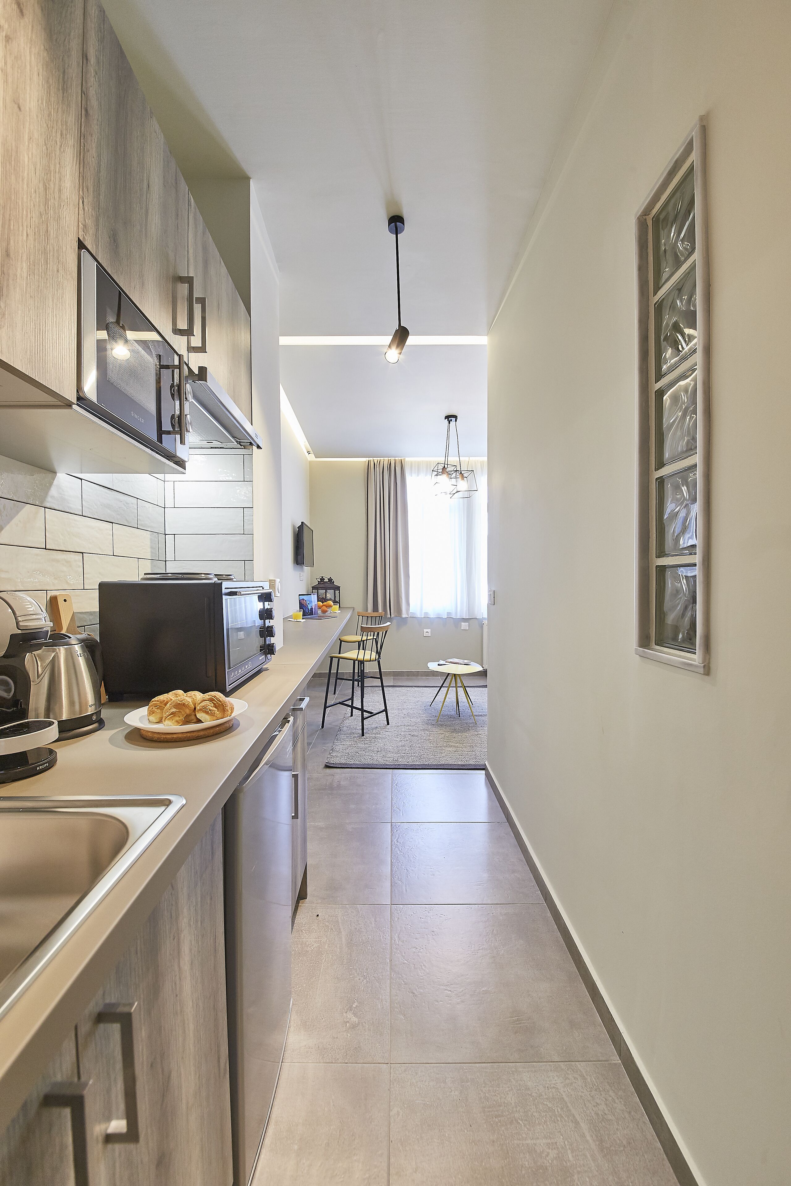 A modern kitchen with a built-in oven, a coffee maker, and a toaster.