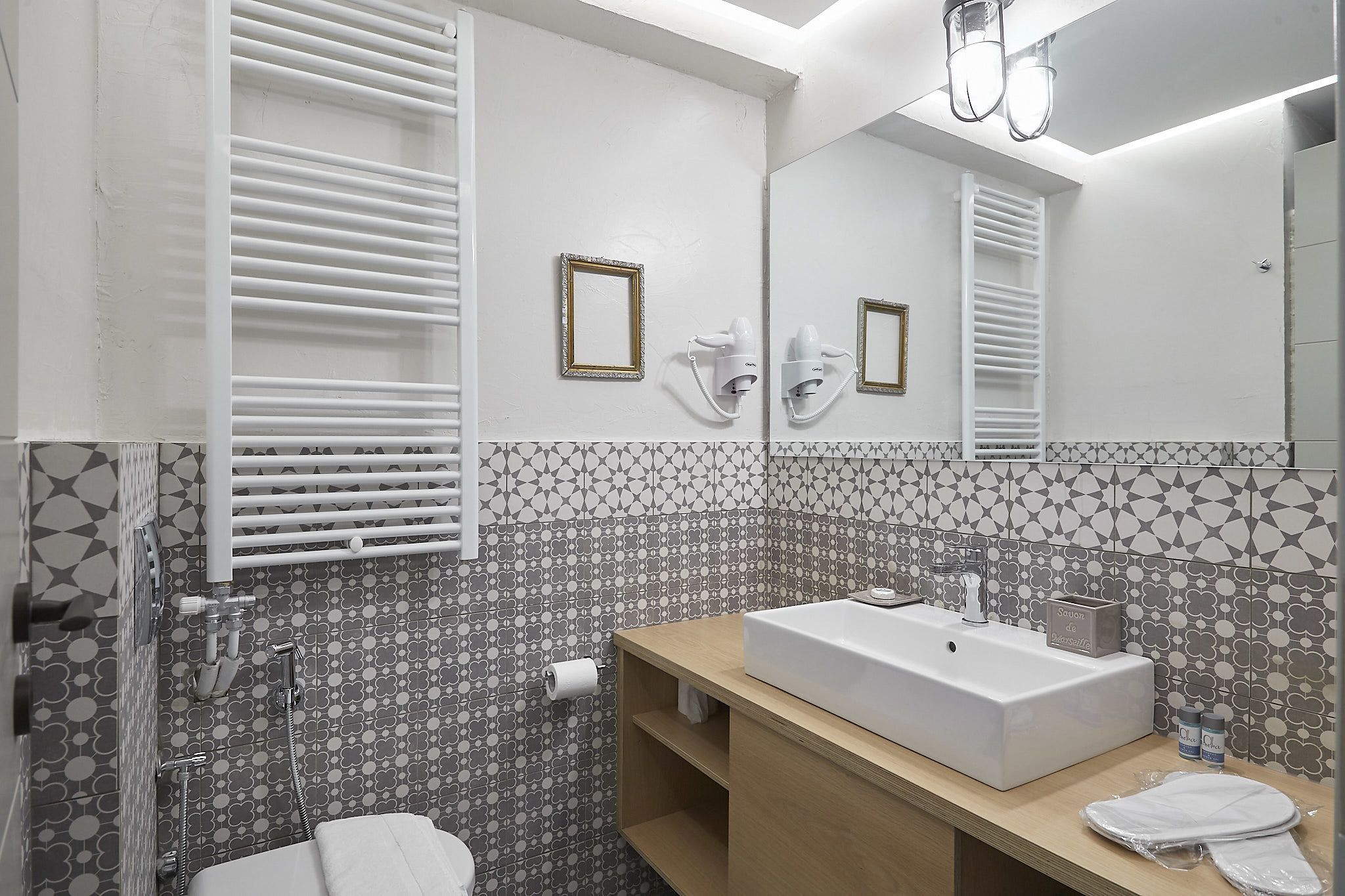 A bathroom with a white sink, towel rack, and a mirror.