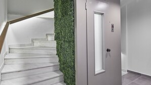 A staircase with a green wall and a door with a light switch. - toStay loft (Athens)