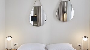 A hotel room with a bed, two wall-mounted mirrors, and an air conditioning unit. - toStay loft (Athens)