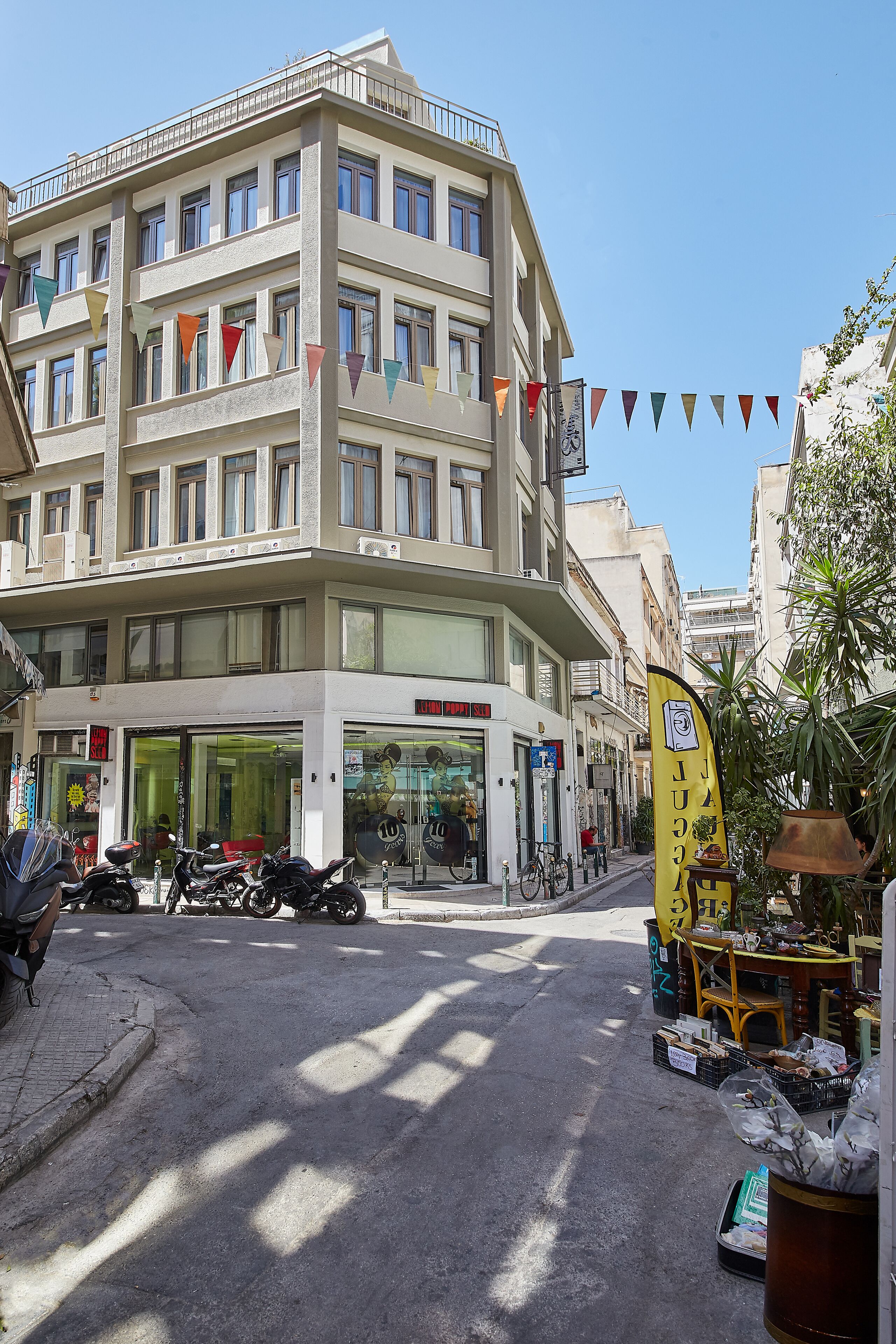 A multi-story building with balconies, a ground-level shop, and a yellow sign.