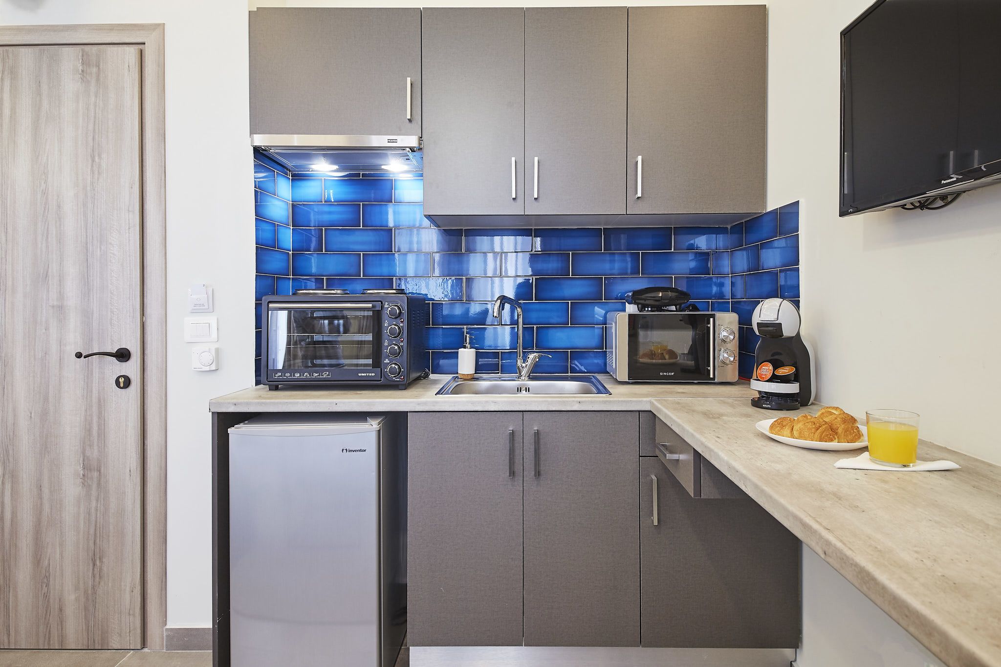 Una cocina compacta con microondas, tostadora y cafetera.