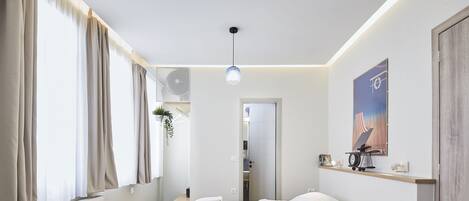 A modern bedroom with a bed, bedside tables, a radiator, and a window with curtains.