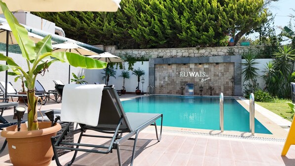 Piscine extérieure, parasols de plage, chaises longues