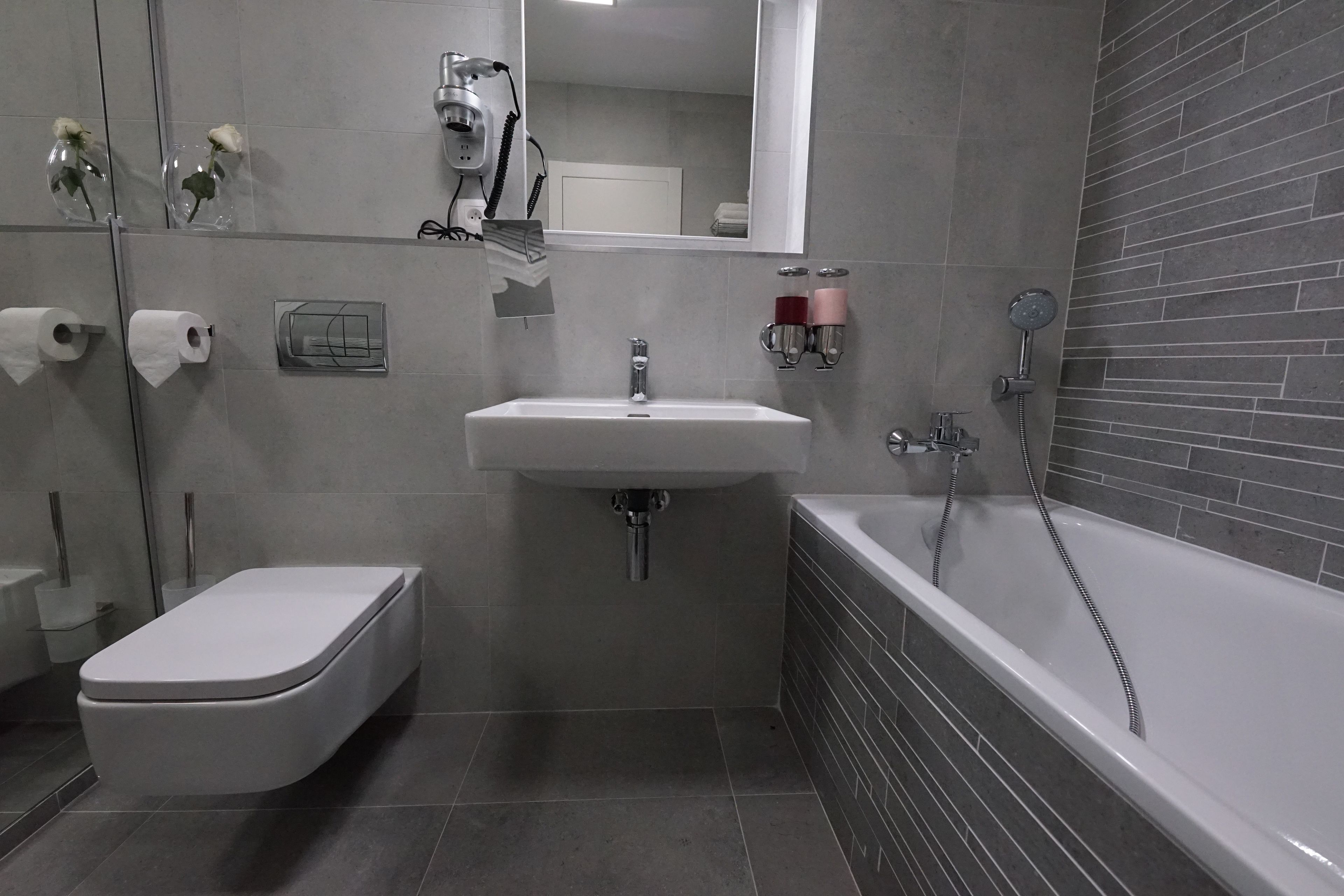 A modern bathroom with a toilet, sink, and bathtub.