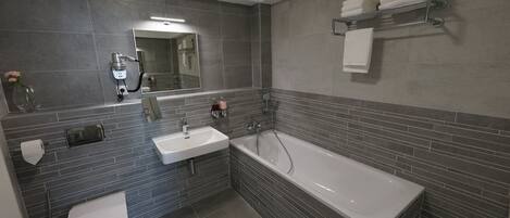 A modern bathroom with a toilet, sink, and bathtub.