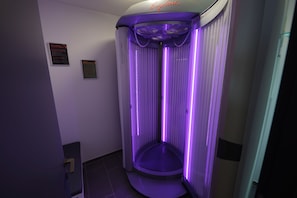 Experience rejuvenation in this serene space, featuring a treatment area with a curved, enclosed structure and LED lighting.