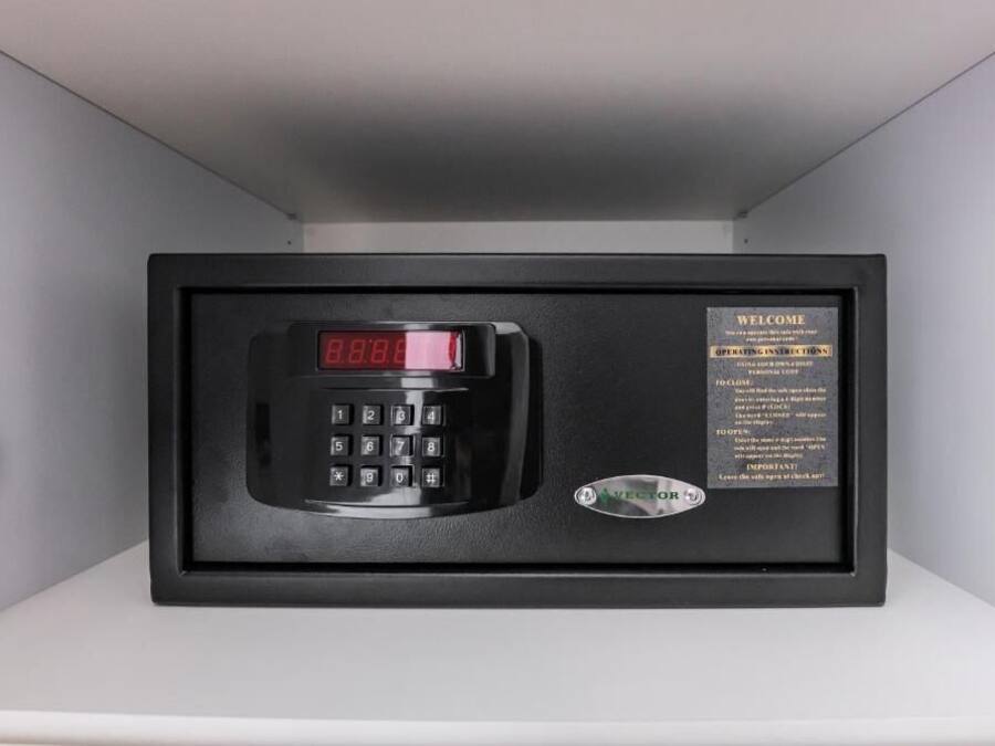 Um painel de segurança preto com visor digital, uma placa de boas-vindas e instruções de uso.