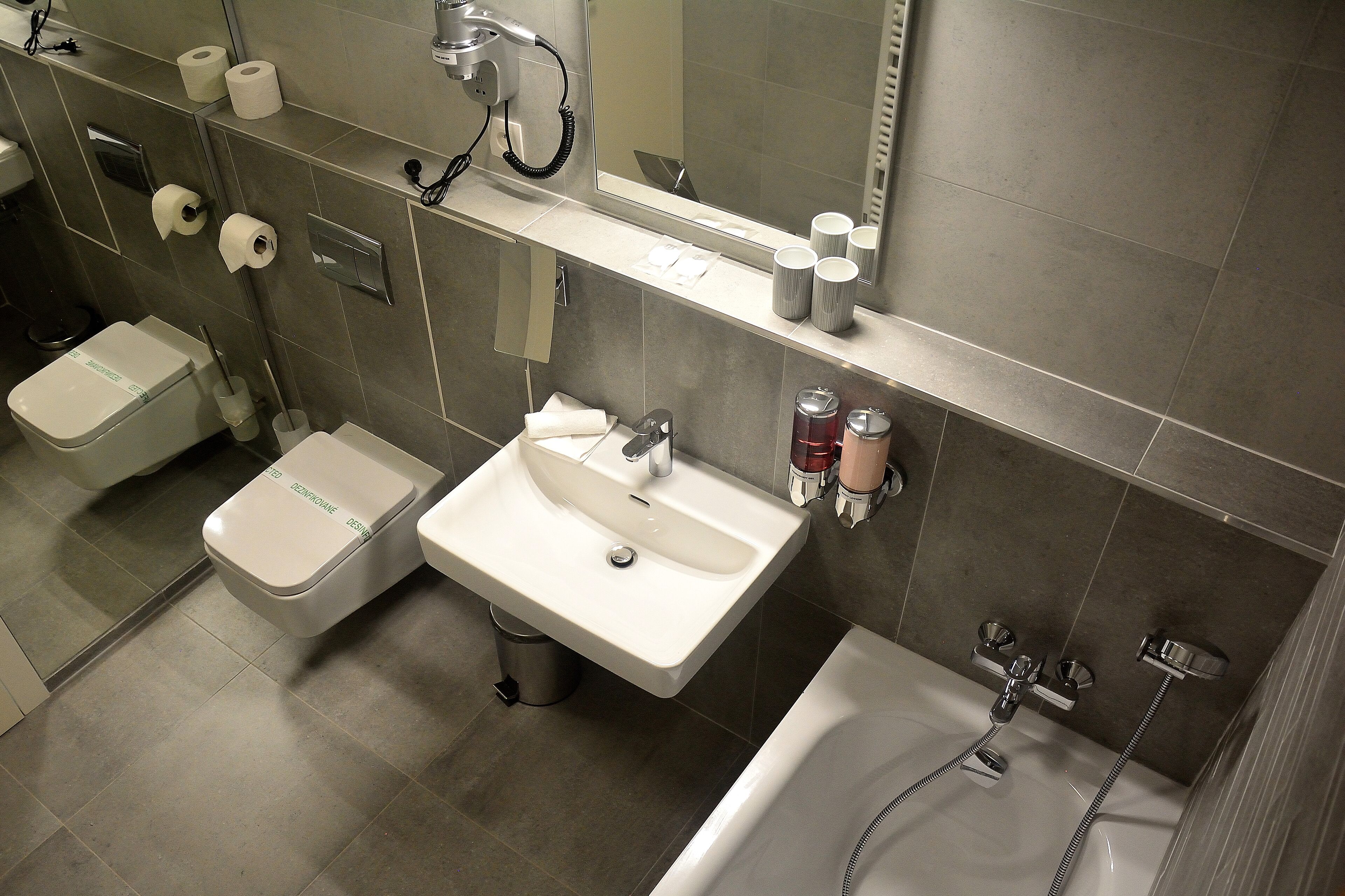 A modern bathroom with a toilet, sink, and bathtub.