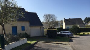A residential street with houses, a parked car, and a clear sky. - little house by the sea (Piriac-sur-Mer)