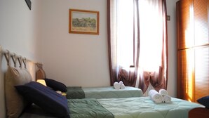 A hotel room with two beds, a painting on the wall, and a window with curtains. - BNBOOK BORROMEO 1 RHO (RHO)