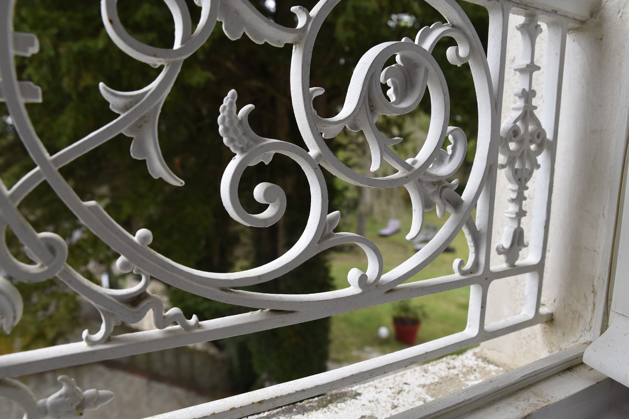 A close-up of ornate white metal railings with intricate designs.