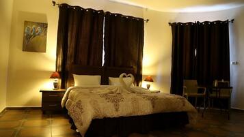 A hotel room with a large bed, two bedside tables with lamps, a chair, and a painting on the wall.