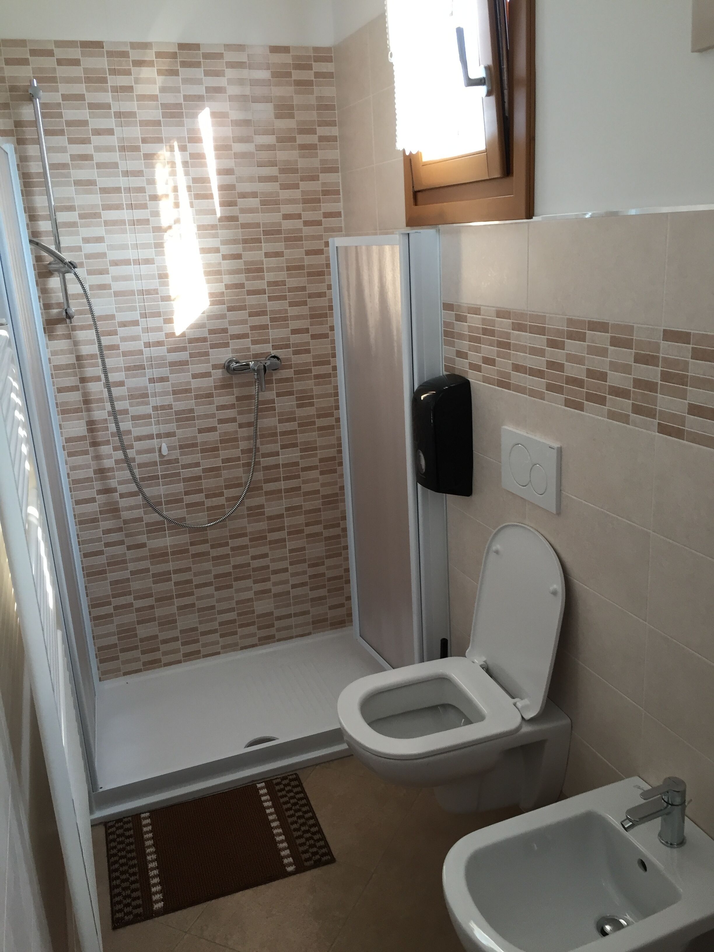 Un baño con ducha, inodoro y lavabo.