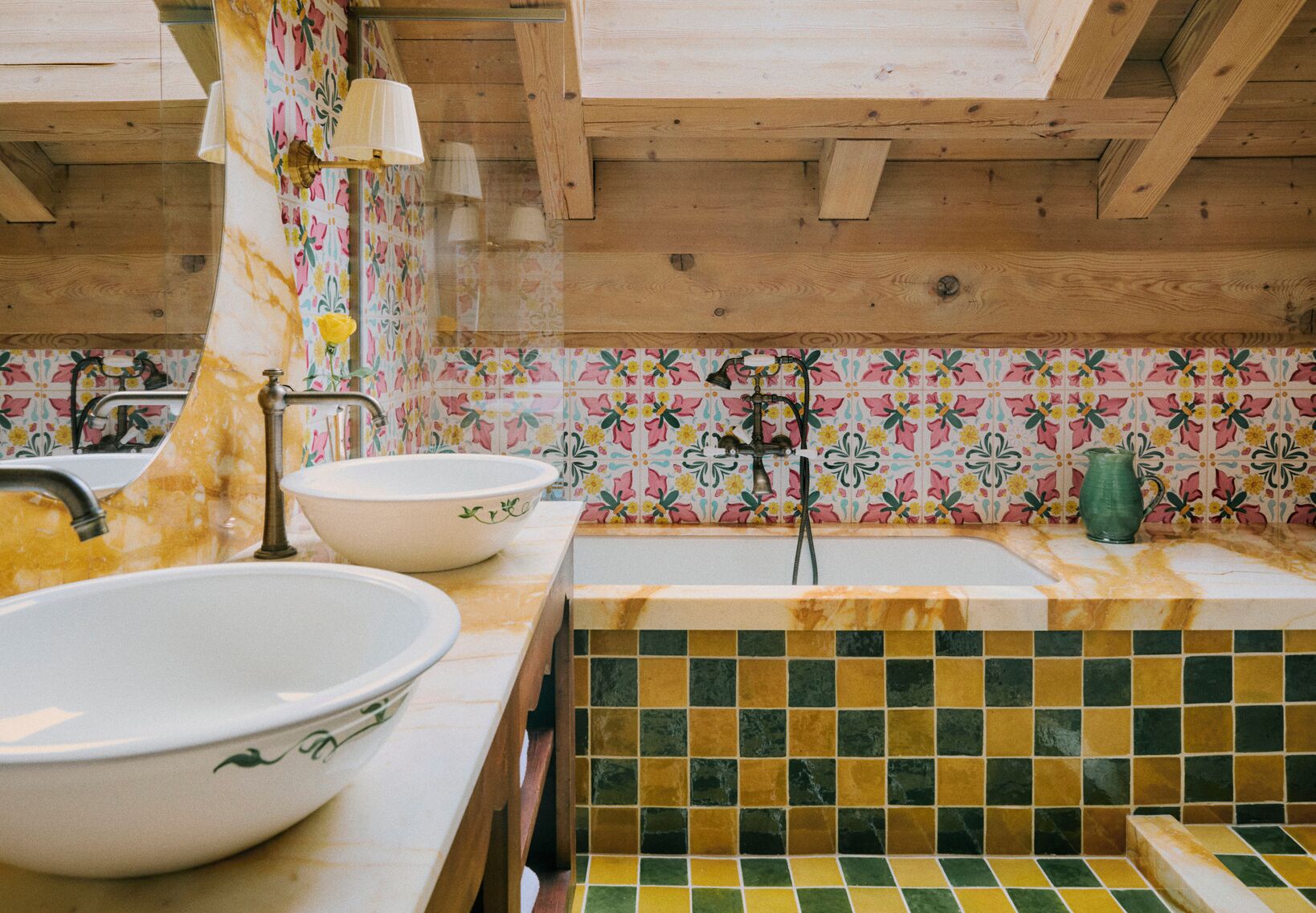 Cocina con vigas de madera, dos cuencos blancos grandes, un lavamanos y un protector de salpicaduras colorido.