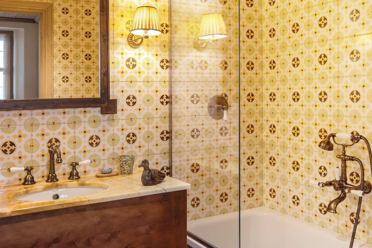 A bathroom with a sink, mirror, and bathtub.
