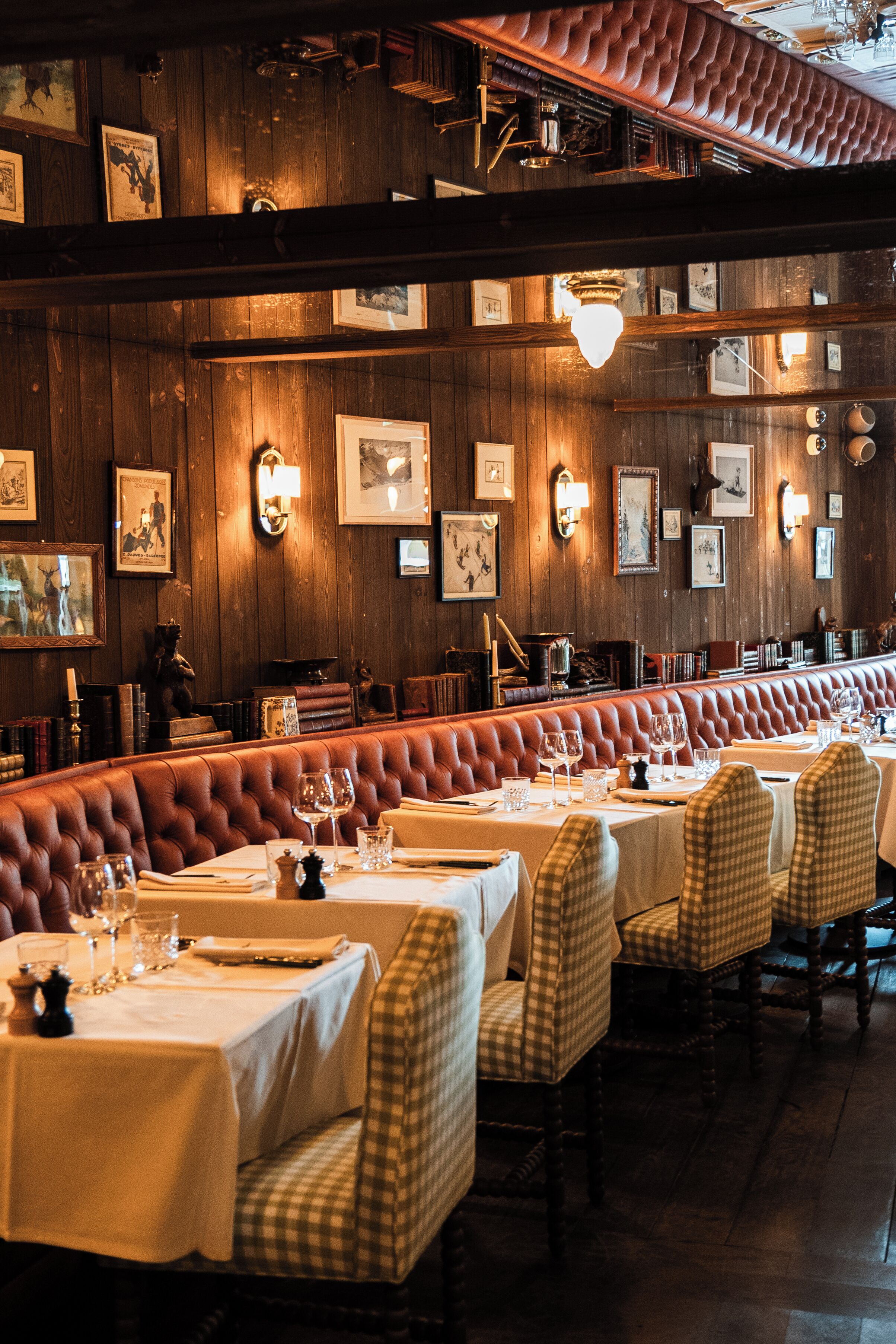 Un restaurant aux murs en bois, orné de tableaux encadrés, et doté d’un long banc pour s’asseoir.