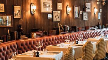 Un restaurant aux murs en bois, orné de tableaux encadrés, et doté d’un long banc pour s’asseoir.