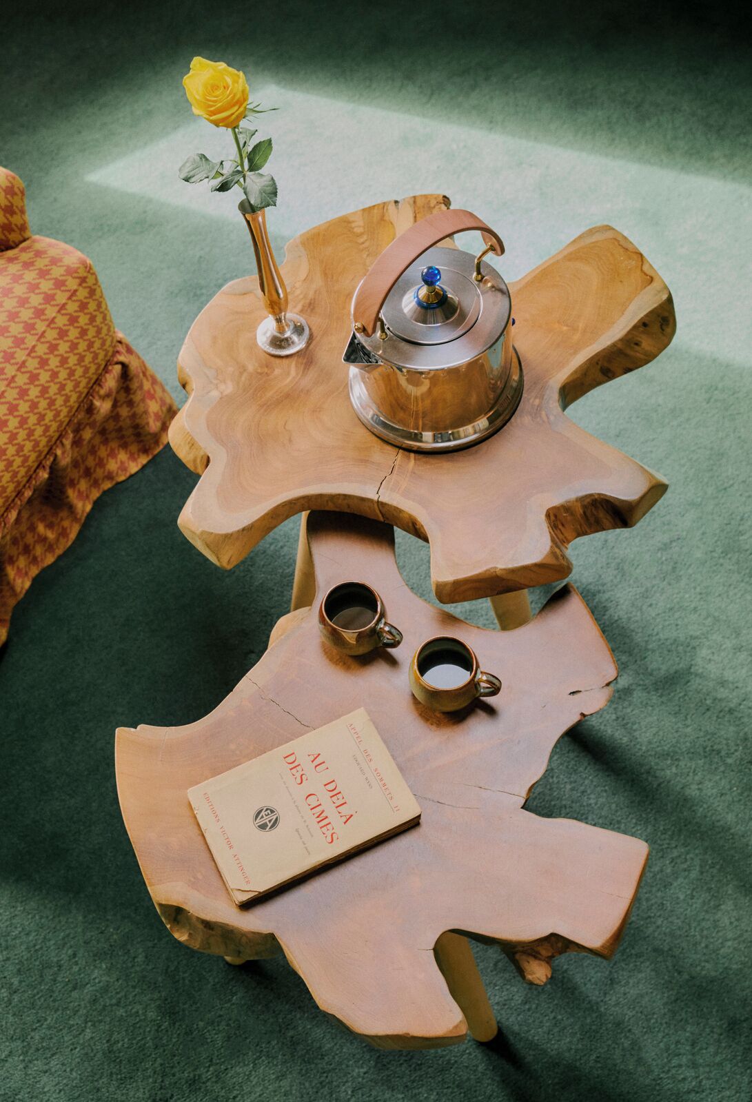 Une table en bois avec un livre, deux tasses et une théière.