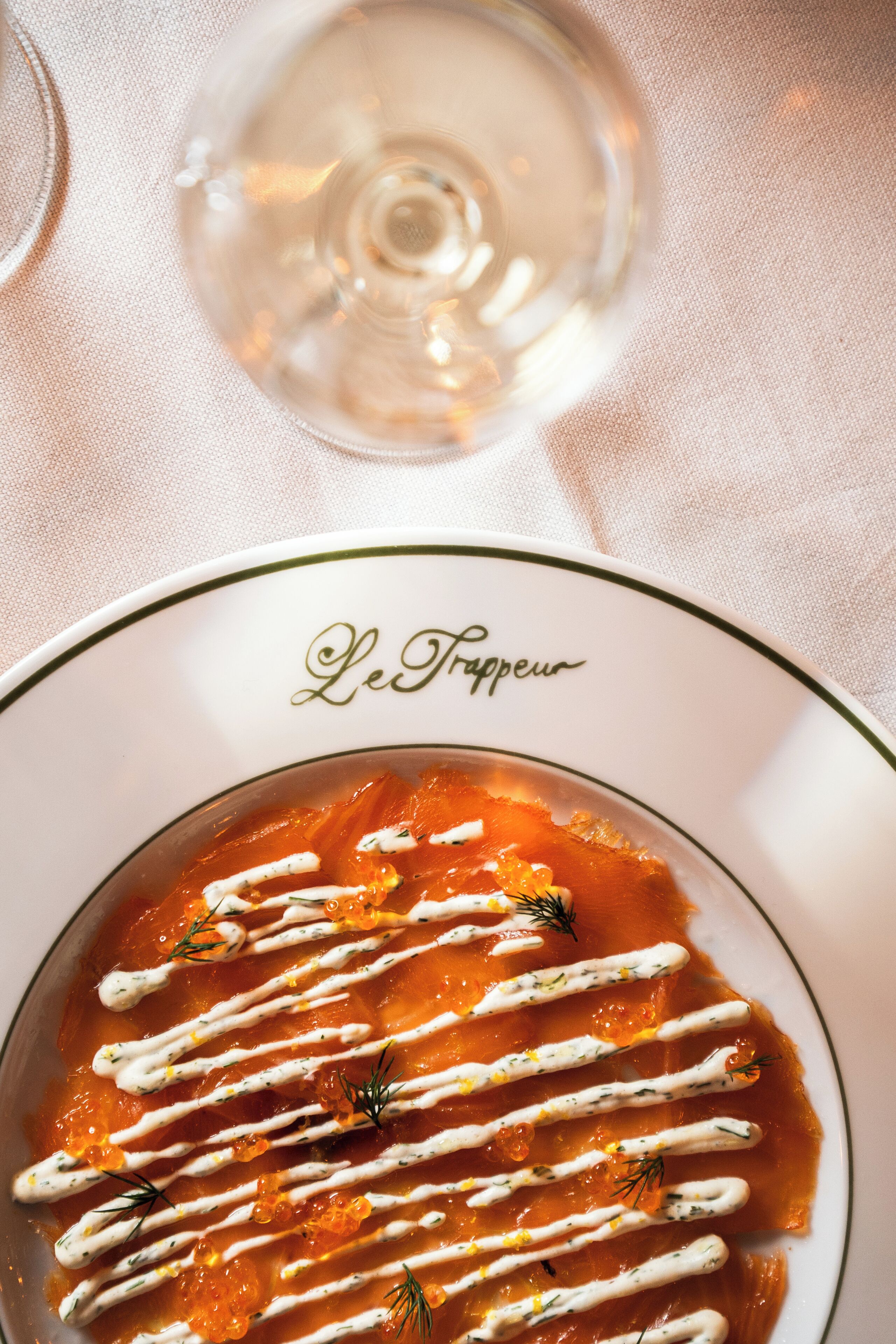 Un plato de comida con borde blanco y detalles verdes, identificado como "Le Frappéu".