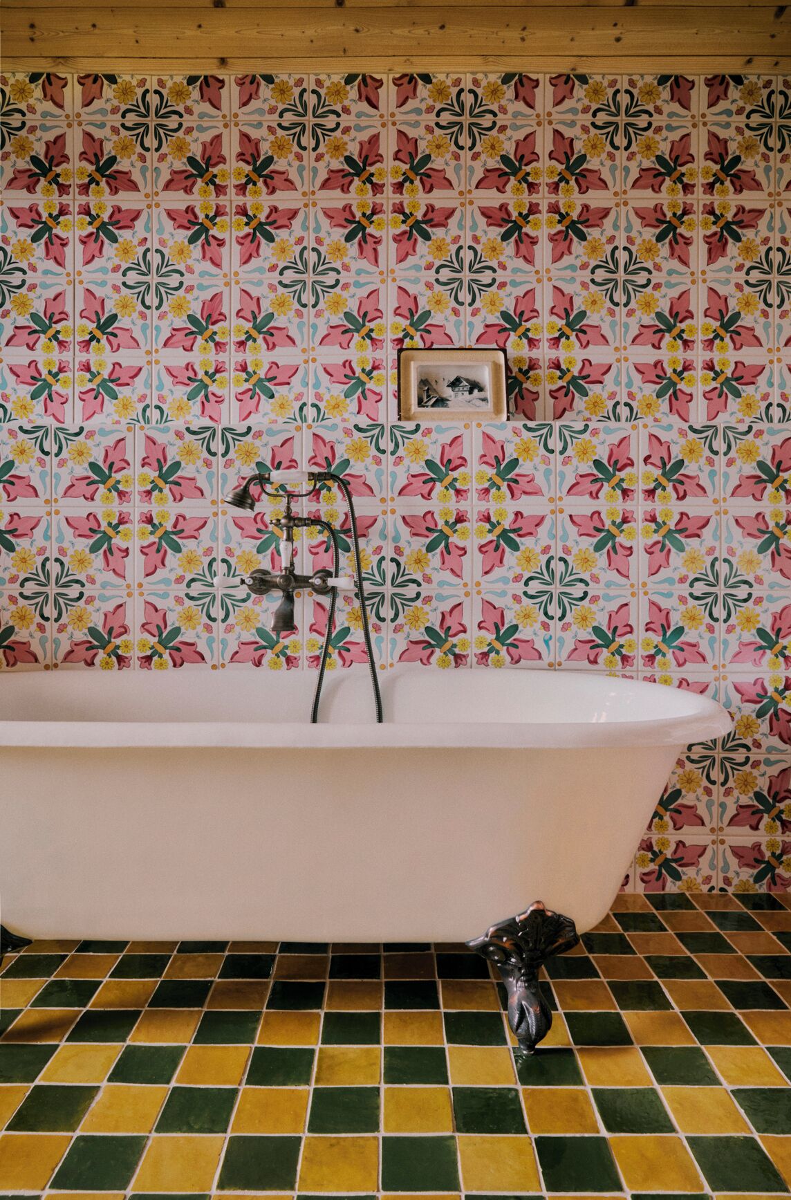 A bathroom with a freestanding bathtub, a wall-mounted sink, and a tiled floor.