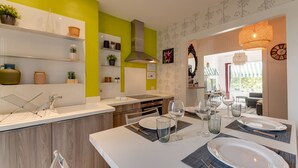 A modern kitchen with a dining area set for four. - 🎖 Le Baulier - 2 bedrooms apartment (Annecy)