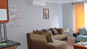 A living room with two sofas, a coffee table, and a small side table. - Africa Emerald at 47 Petronella (Kempton Park)