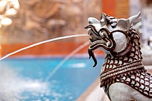 Escultura decorativa de cabeça de cavalo perto de uma piscina.