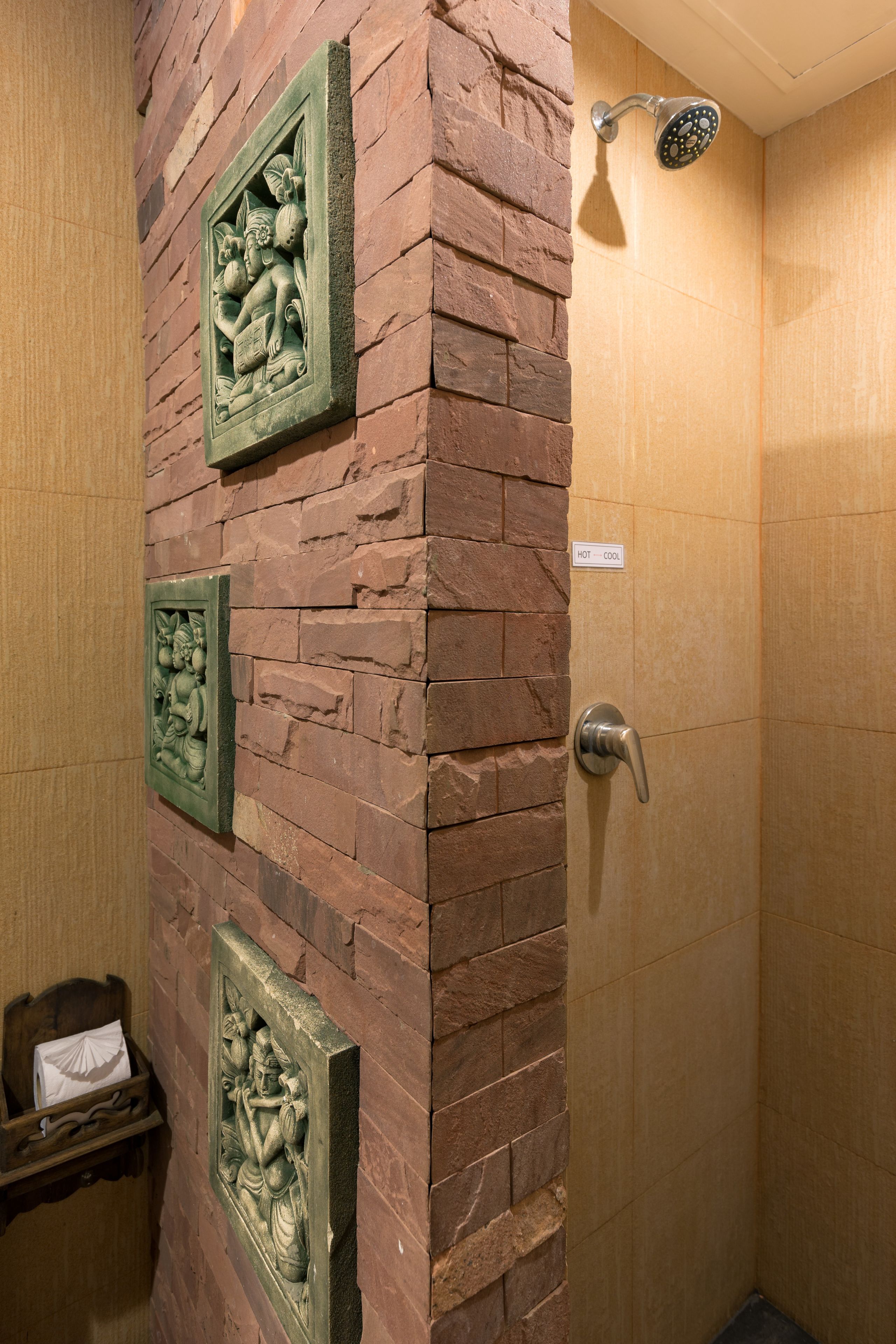 A bathroom with a shower, a towel rack, and a sign indicating hot and cool water.