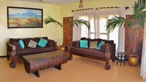 Ein Wohnzimmer mit zwei Sofas, einem Couchtisch und einem Gemälde an der Wand.