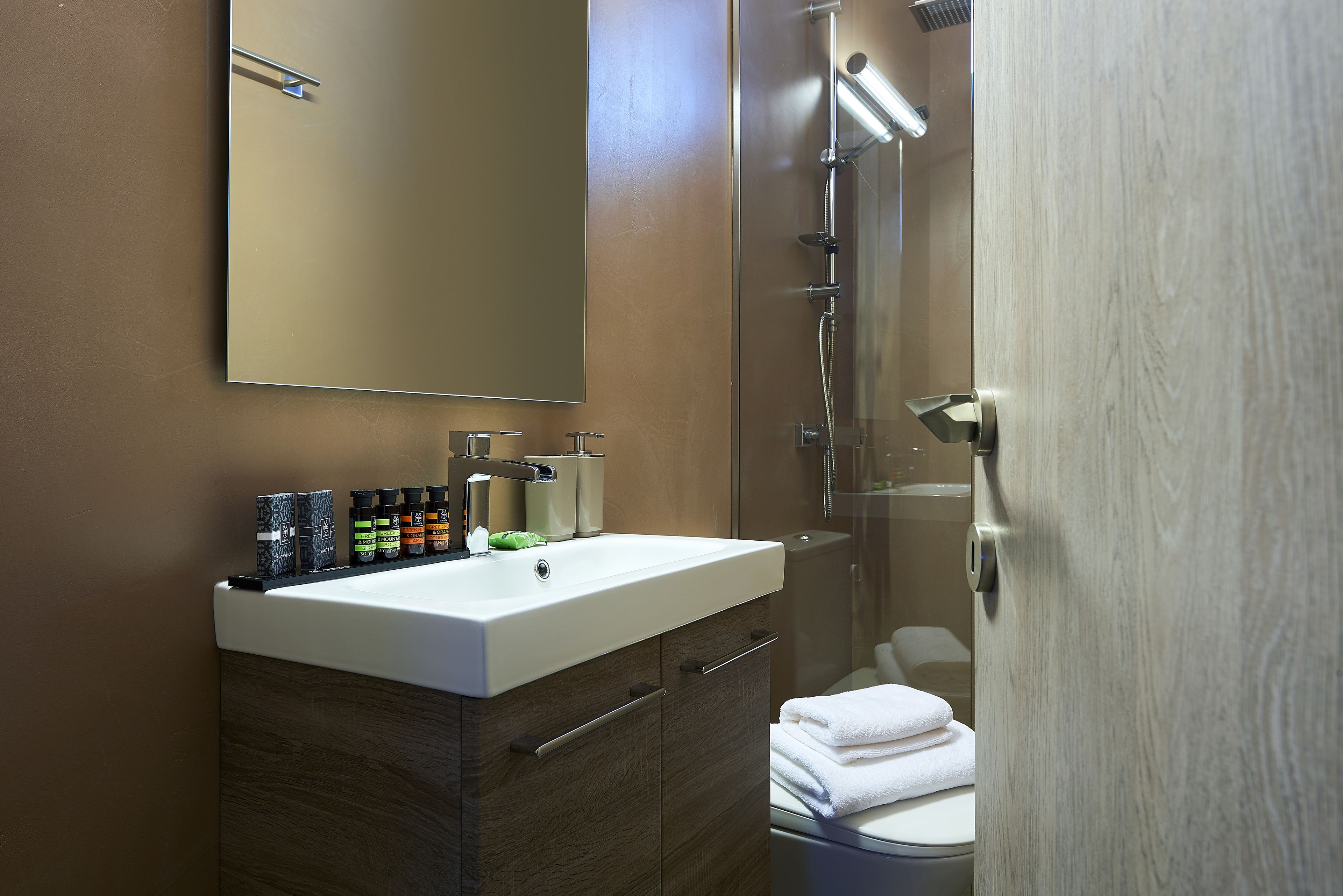 Une salle de bain moderne avec un grand miroir, un lavabo et une douche.