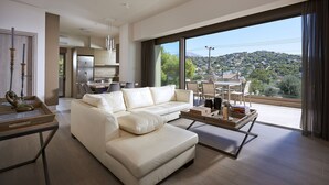Un saló modern amb un sofà blanc, una zona de menjador amb taula i cadires, i una cuina al fons.