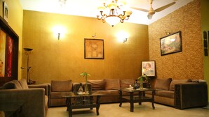 A living room with a sofa set, a coffee table, and a chandelier. - Hotel Sweet Inn (Lahore)