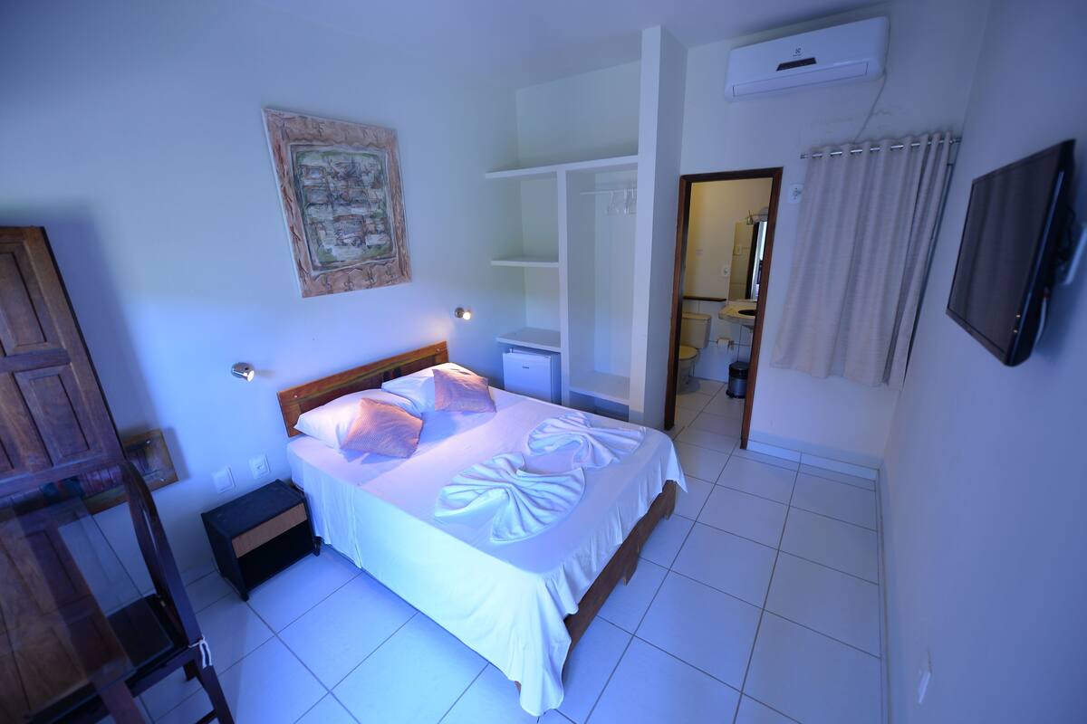 A bedroom with a bed, bedside table, and a wardrobe.