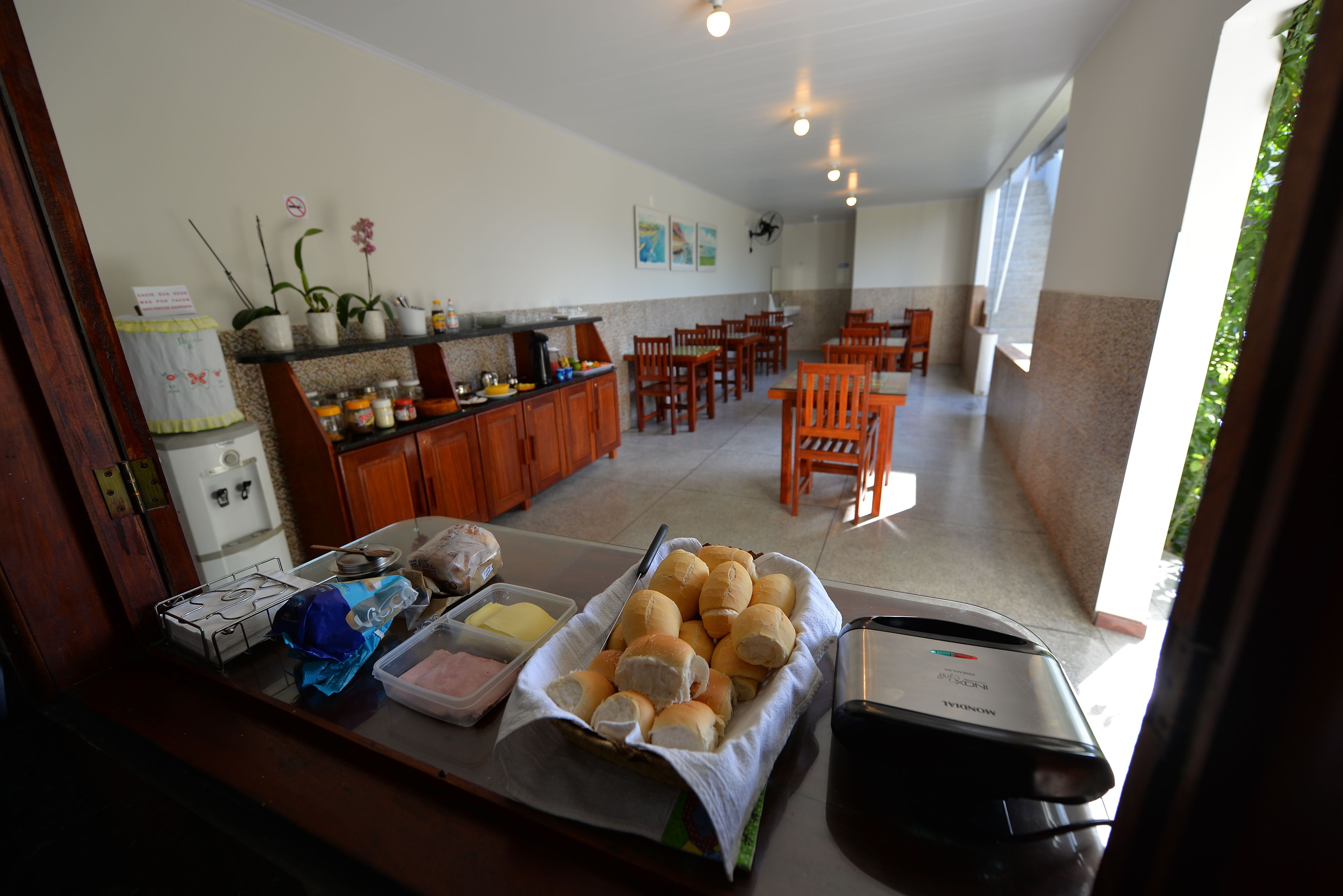 A breakfast buffet setup with bread rolls, butter, and condiments.