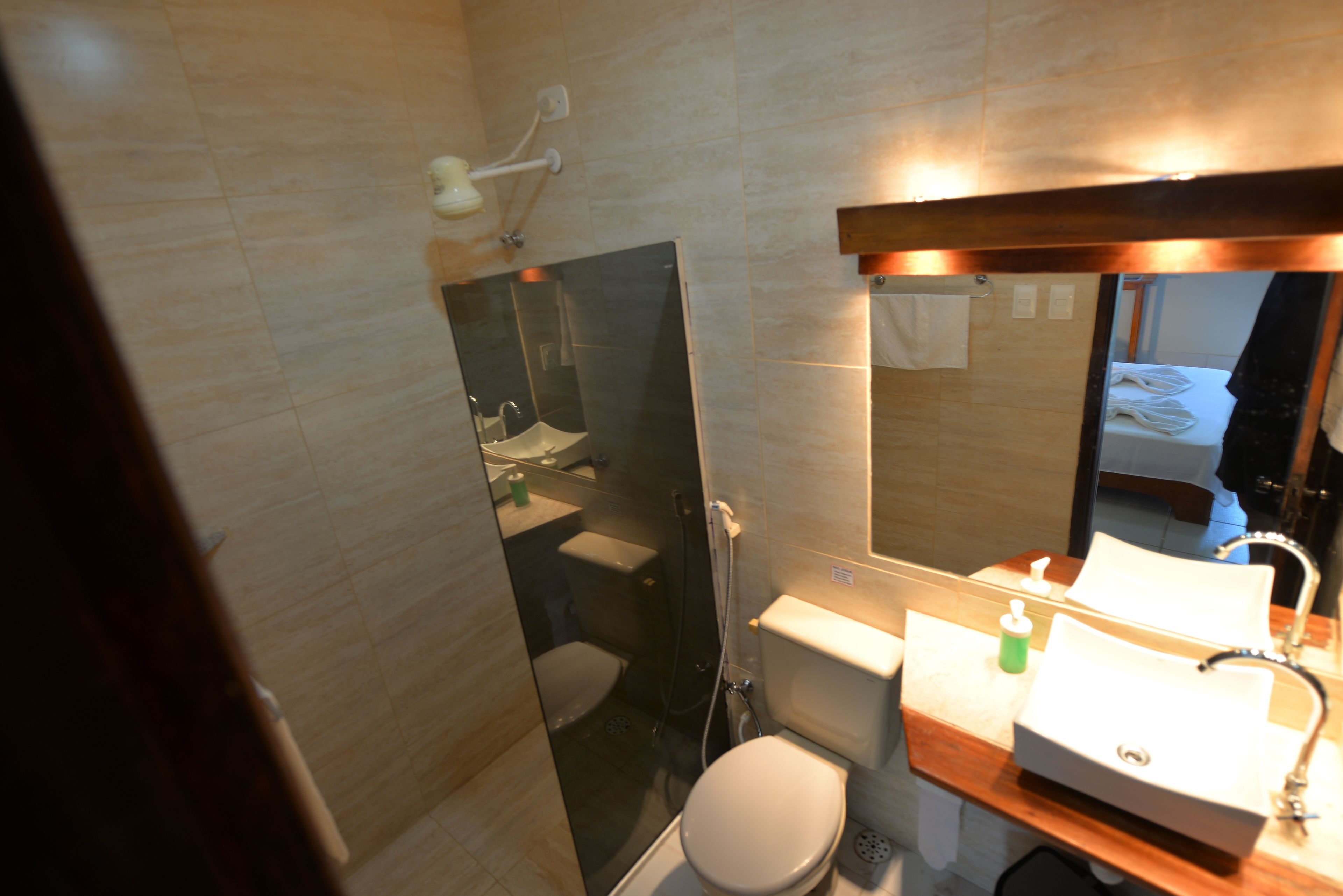 A modern bathroom with a glass shower enclosure, a toilet, and a sink with a mirror above it.