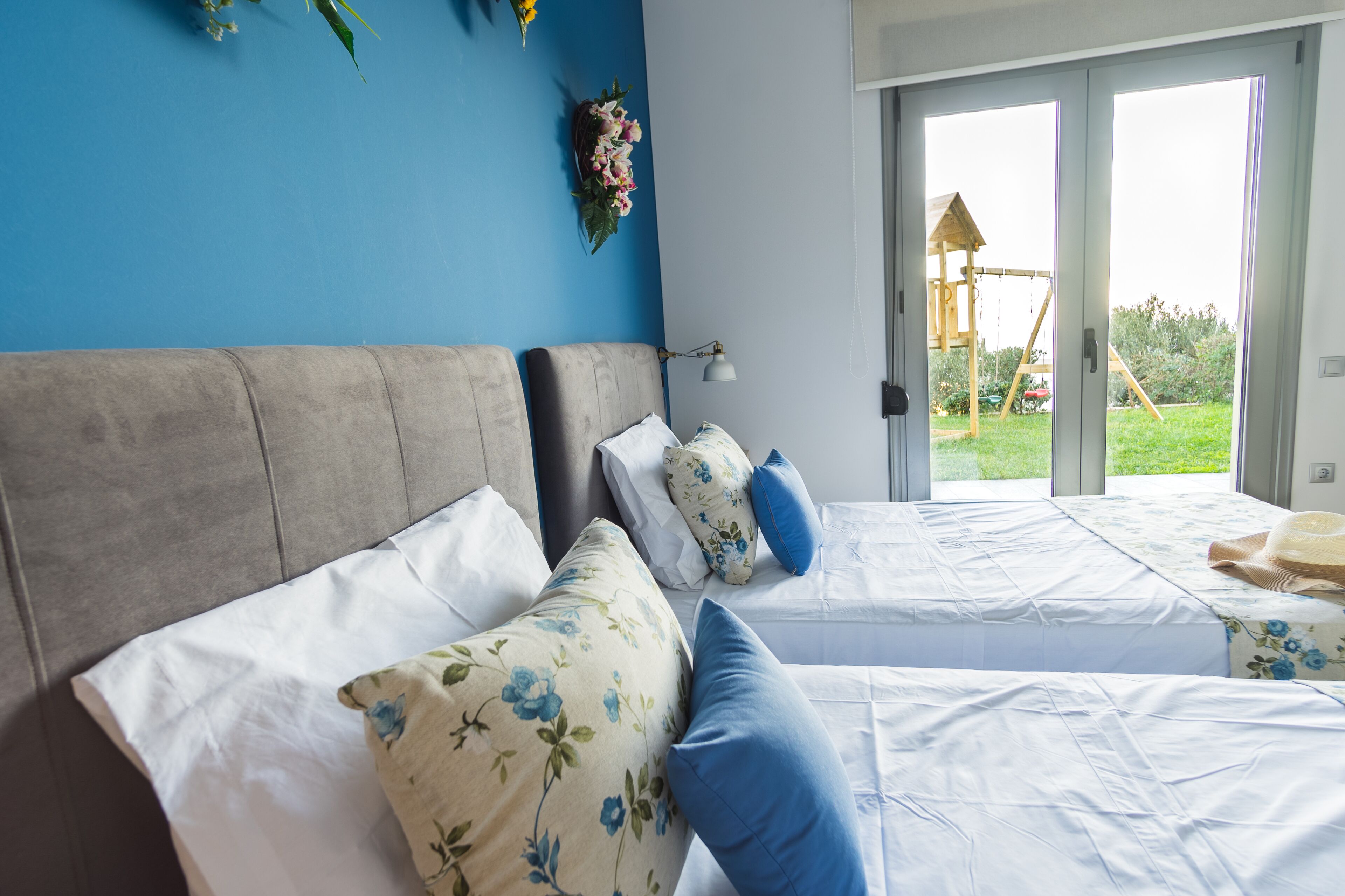 A hotel room with two beds, a large window, and a view of the outdoors.
