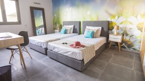 A hotel room with two beds, a desk, and a chair. - Villa Constandinos (Hersonissos)