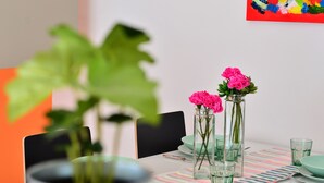 Una mesa de comedor con platos verde azulados, vasos y un mantel a rayas.