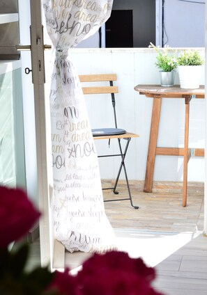 Relax in this serene outdoor space with a bench and table, surrounded by lush greenery and a decorative wall.