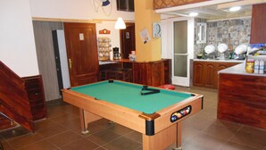Ein Billardtisch in einem Raum mit Holzsäcken und einer Bar.