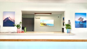 Un área de recepción con techo de madera, una mesa de recepción y tres cuadros en la pared.