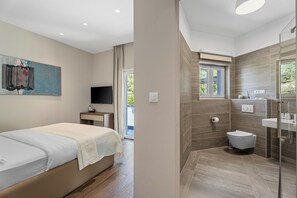 Quarto moderno com cama, TV e um quadro na parede.