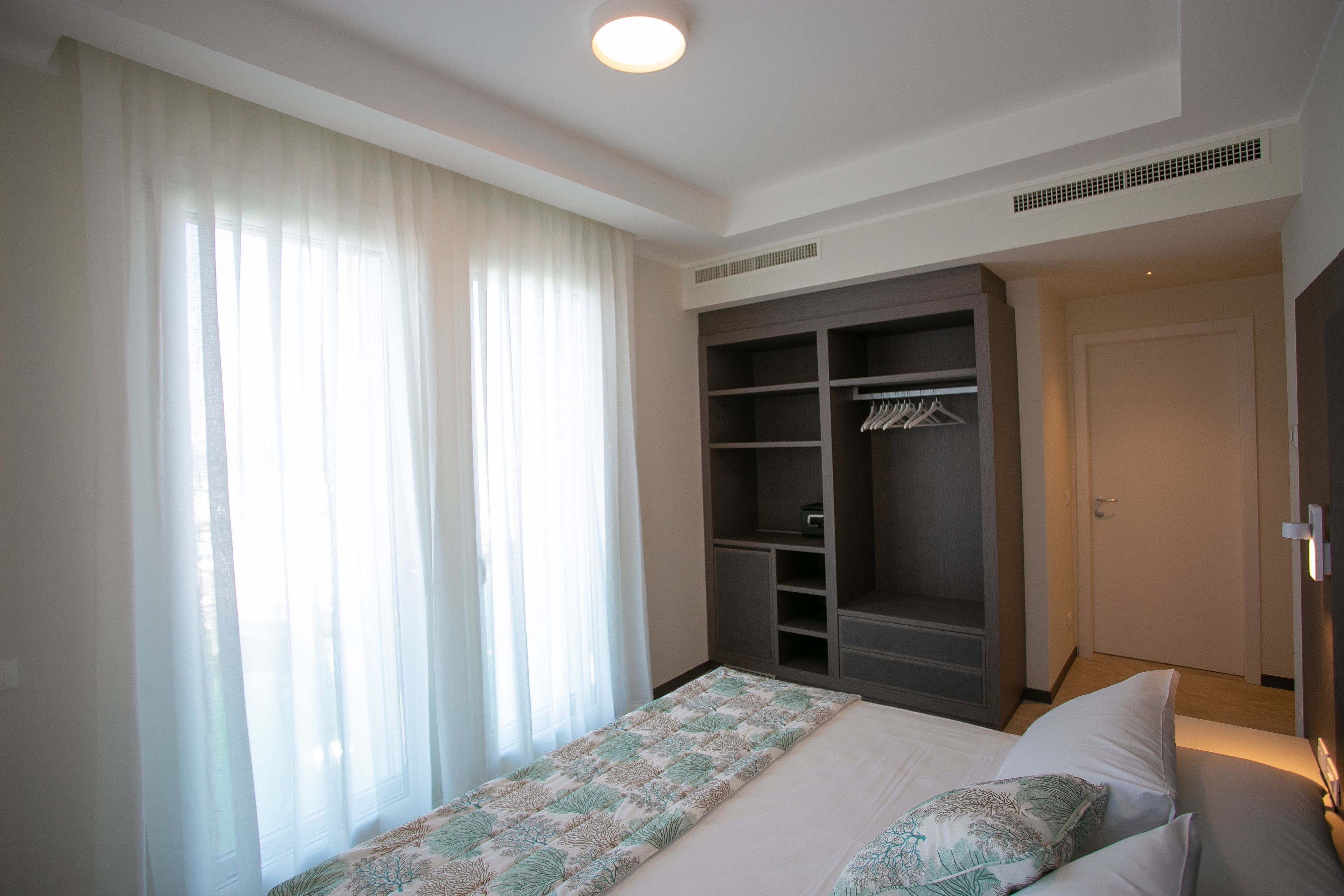 Une chambre à coucher avec un lit, une armoire et une porte.