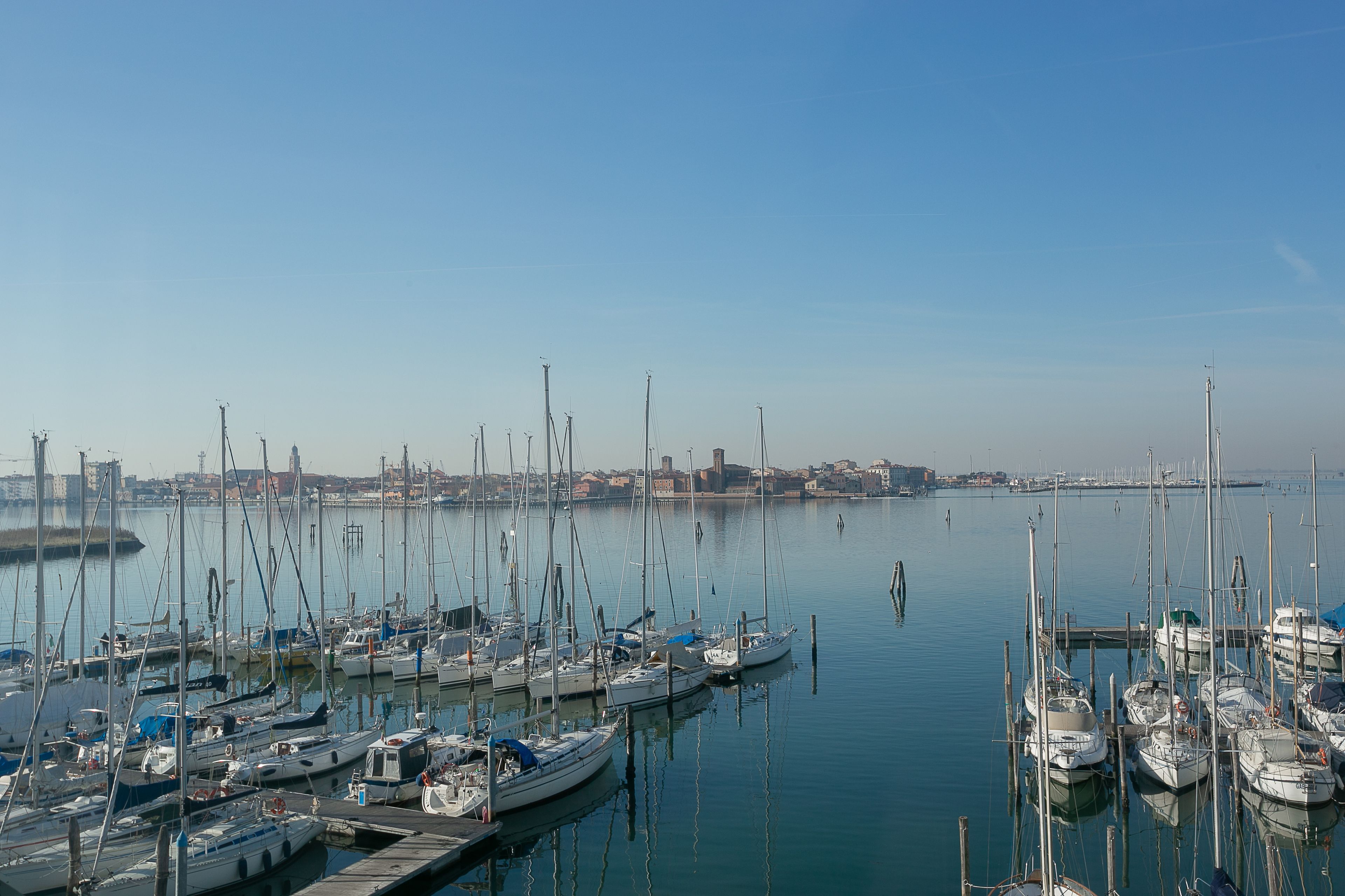 Un port de plaisance où de nombreux bateaux sont amarrés à des quais en bois.