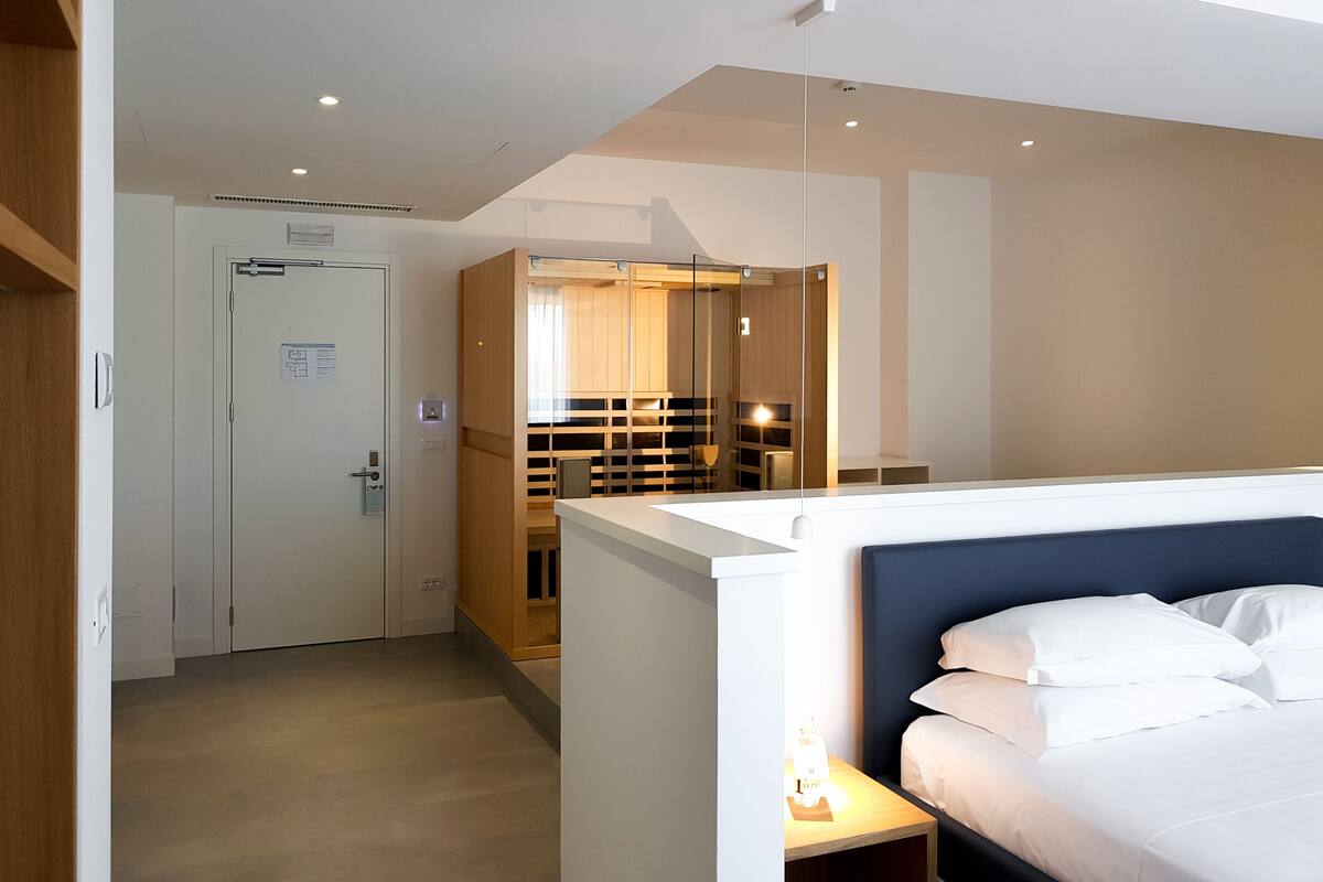 Une chambre d’hôtel avec un lit, une table de chevet et une armoire.