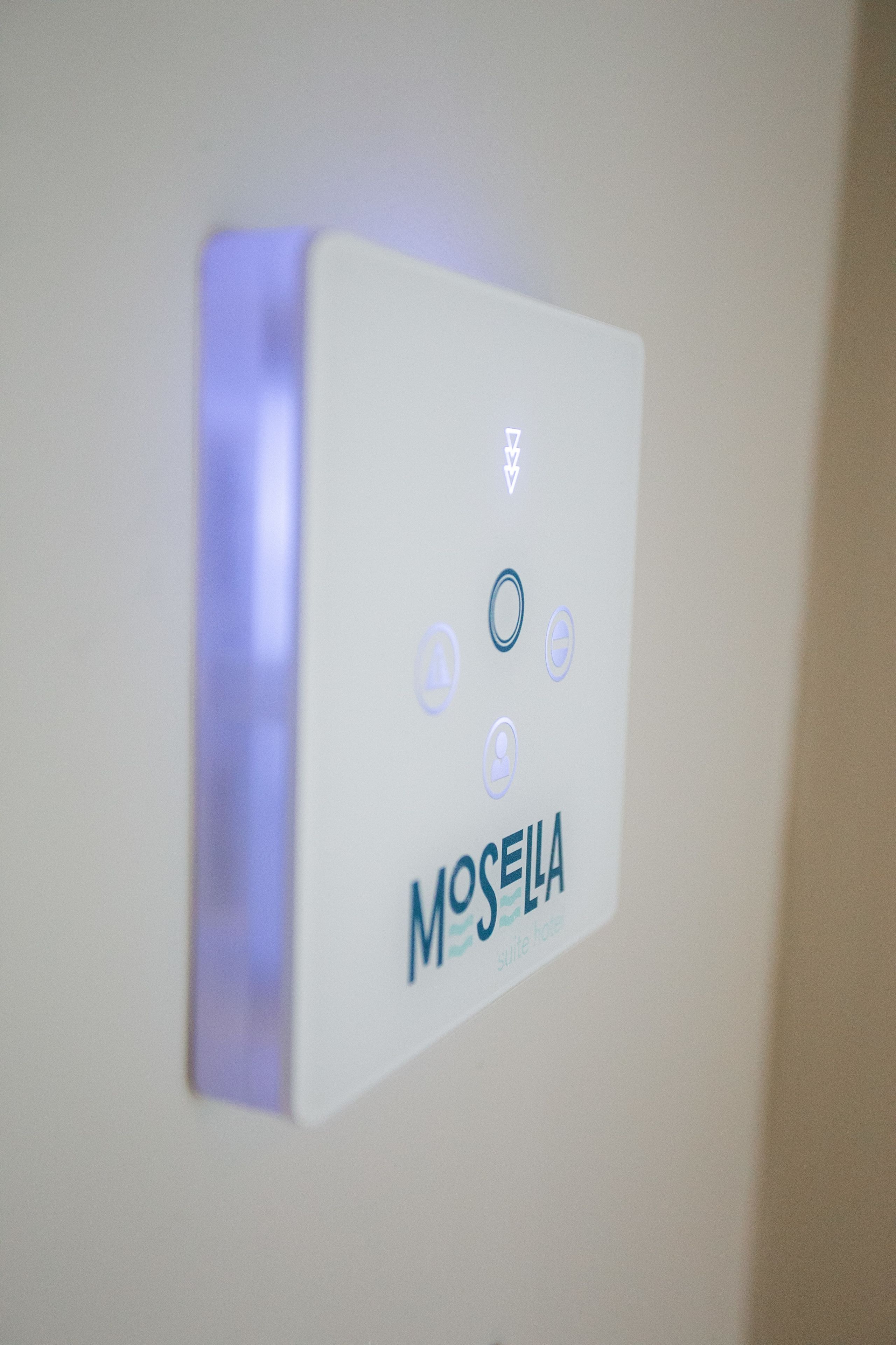 Panel de control instalado en la pared con el nombre de marca "MOSEILA" e iconos que indican las características de la habitación.