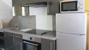Una cocina moderna con electrodomésticos de acero inoxidable, incluyendo un microondas, refrigerador y lavavajillas.