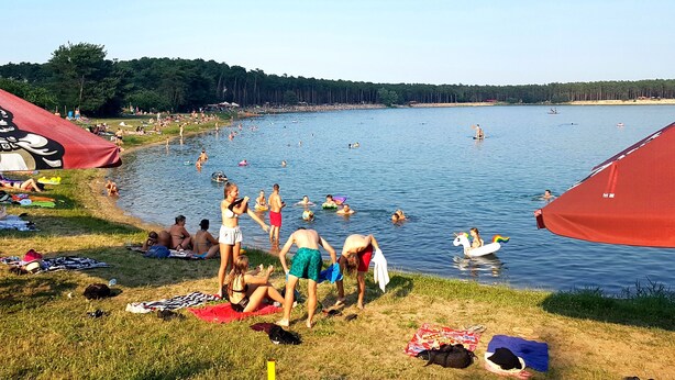A lakeside campsite with tents and people enjoying the water. - Hotel Bor (Lhota)